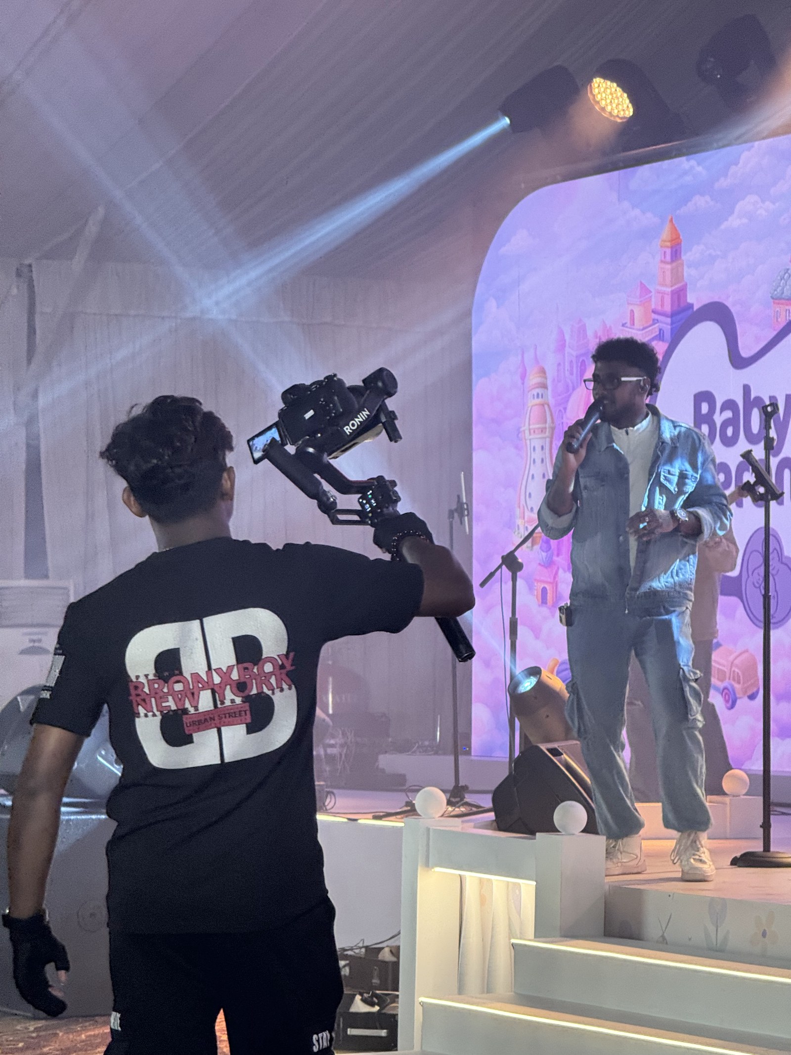 Gimbal operator filming a performer singing on a branded event stage